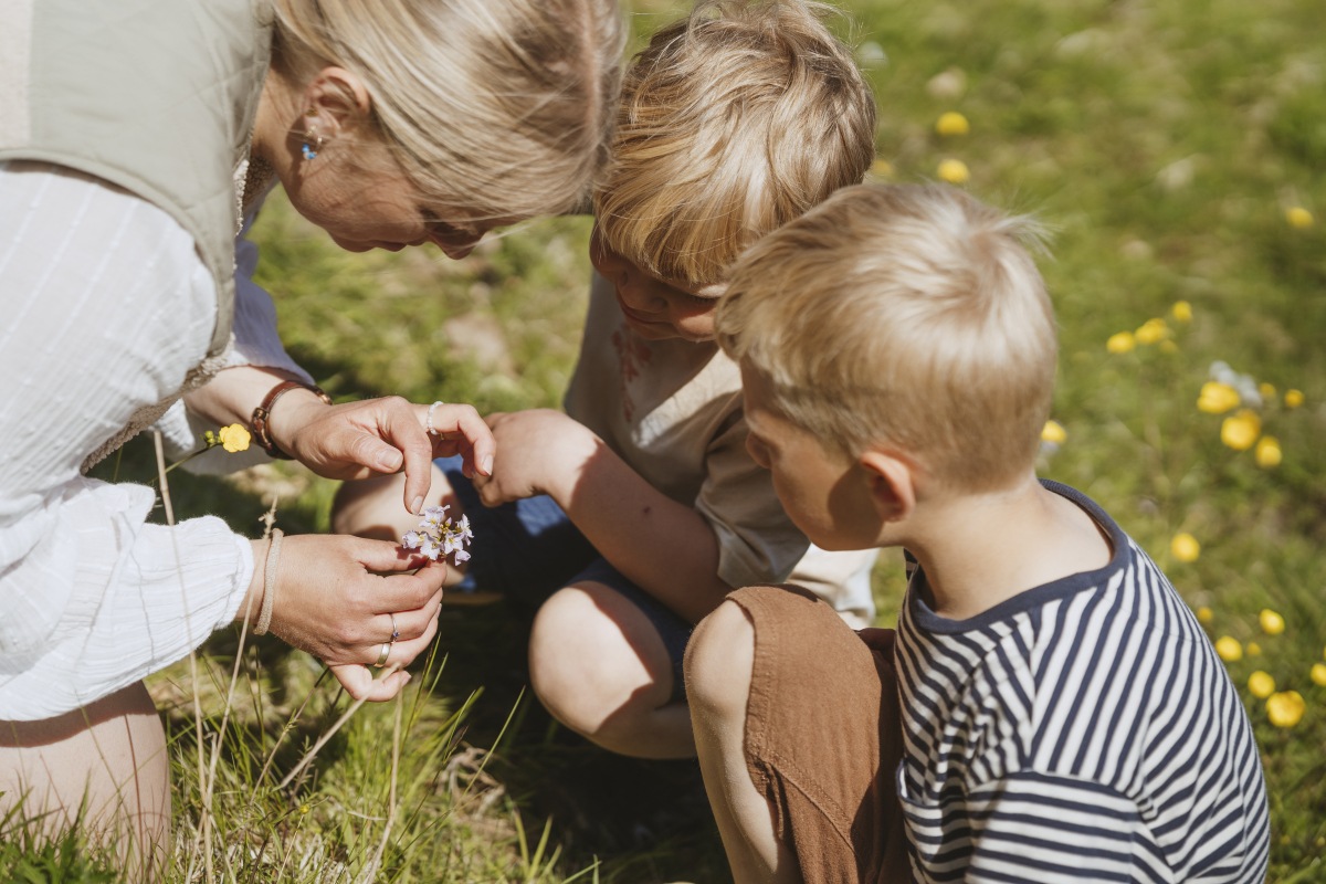 Mor og børn kigger på plante
