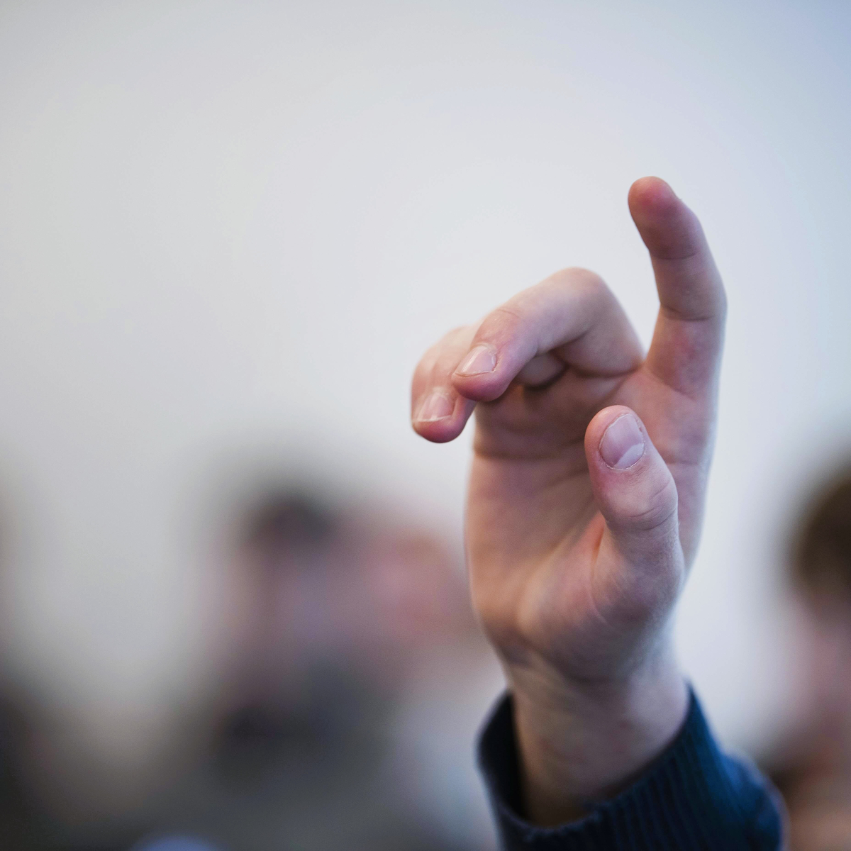 En ung rækker hånden op i vejret