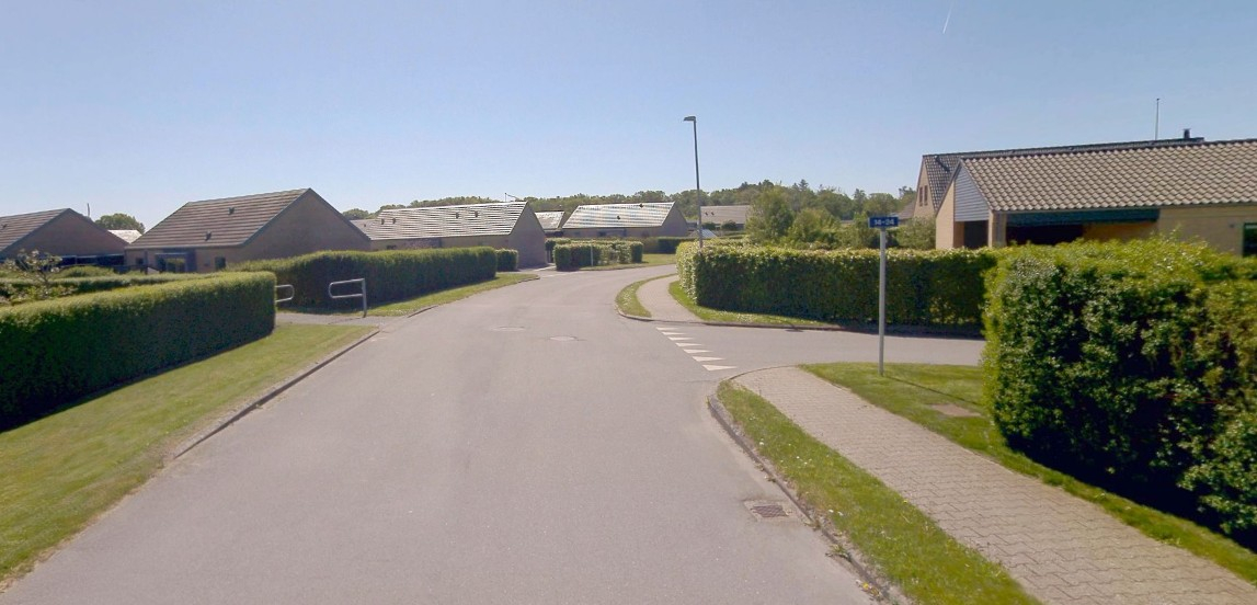 Fotoeksempel på boligvej med kørebane, rendestensrist, kantsten, skillerabat, fortov, yderrabat, sti, stibomme (hastighedsdæmpende foranstaltning), skilt, afmærkning og gadelys. Ansvaret for vedligeholdelse af de nævnte elementer på dette billede overdrages i forbindelse med nedklassificering.