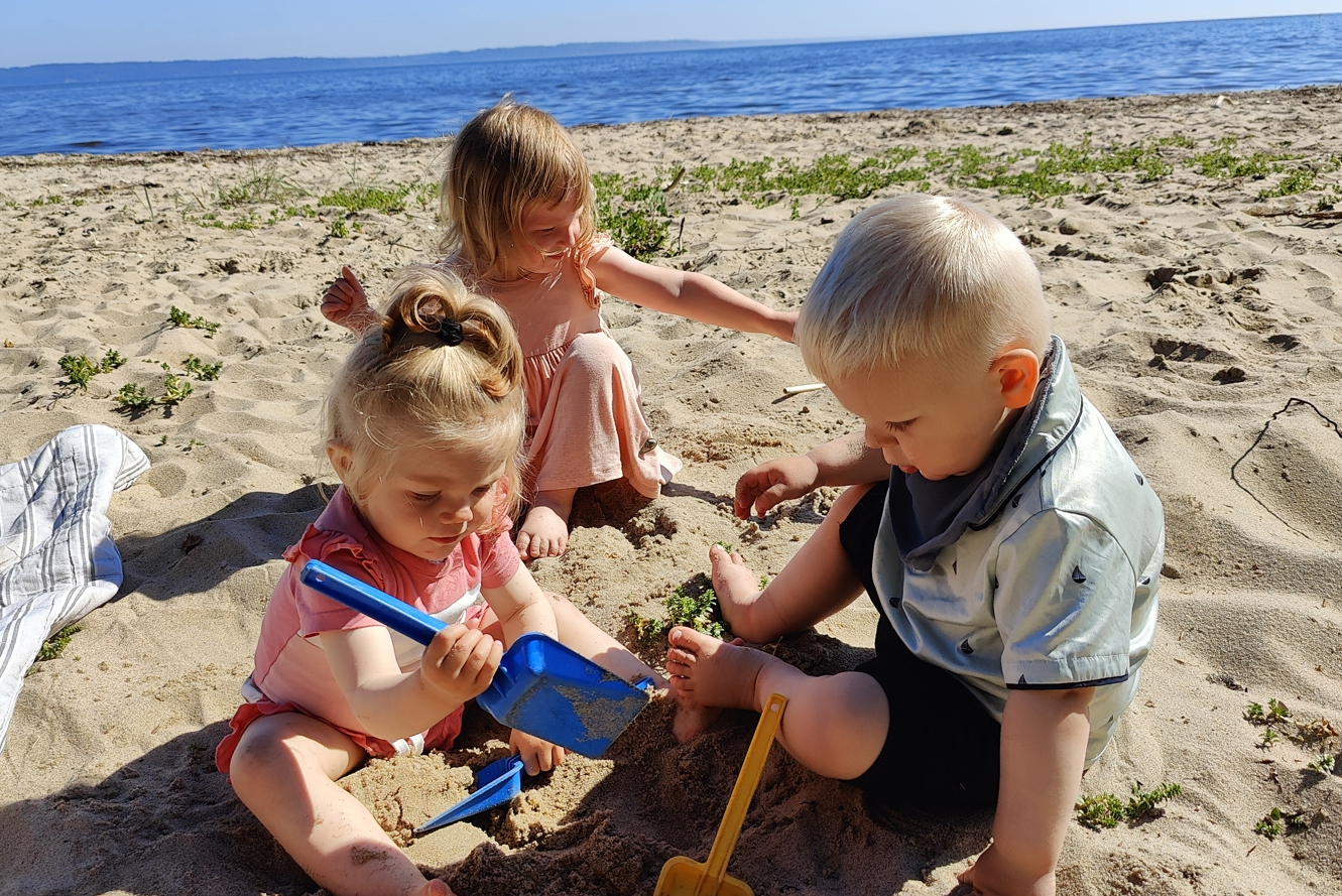 børn leger med sand på strand